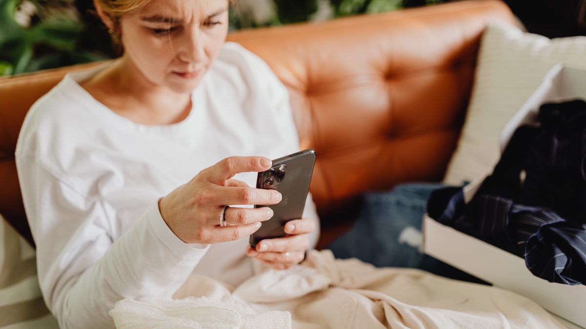 A person relaxed on a couch, scrolling on their phone